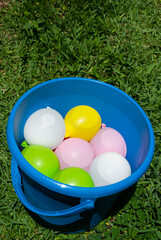 Group of multi colored latex balloons filled with water ready for kid's summer fun.