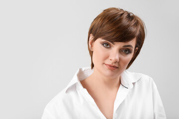 Young woman with beautiful short hair on grey background