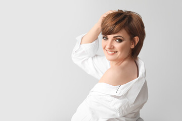 Fototapeta premium Young woman with beautiful short hair on grey background