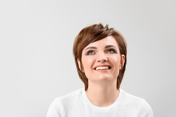 Young woman with beautiful short hair on grey background