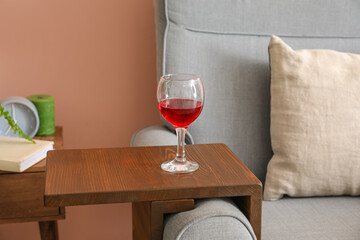 Glass of wine on armrest table in room