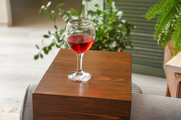Glass of wine on armrest table in room