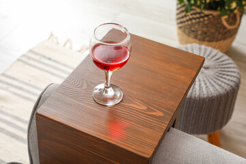 Glass of wine on armrest table in room