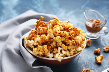 Sweet caramel popcorn on color background
