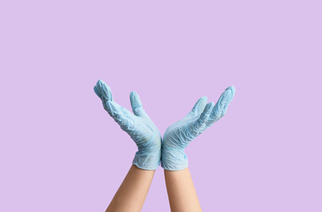 Gesturing hands in protective gloves on color background