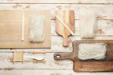 Raw rice noodles on white wooden background