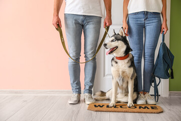 Young couple with cute Husky dog in hallway
