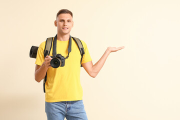 Male tourist with camera on color background