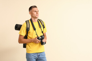 Male tourist with camera on color background