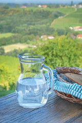 Glass jug with water and bread, vertical format