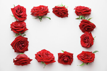 Frame made of beautiful red roses on color background