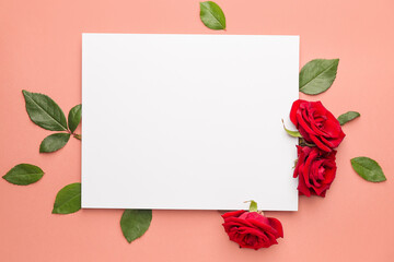 Beautiful red roses, blank card and leaves on color background