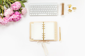 Neatly arranged office stationery with modern gadgets, devices, coffee and flowers on white desk.