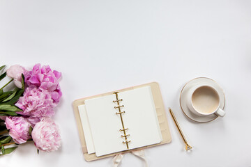Notepad and beige leather covered diary with clean sheets, gold pen, cup of flat white coffee