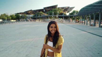 young pretty athletic girl smiling with a longboard in modern city. Slowmotion shot