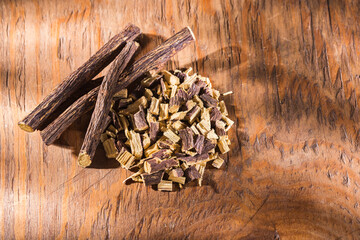 Licorice root in bowl on wooden background