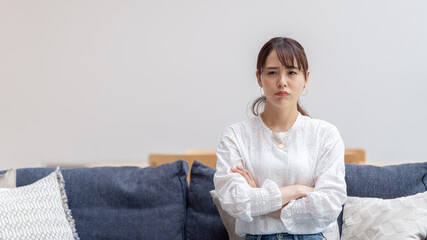 ソファーに不機嫌な顔で座る女性