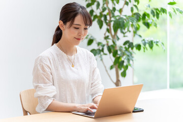 リビングでノートパソコンを使う女性