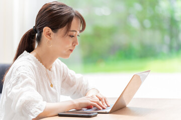 リビングでノートパソコンを使う女性