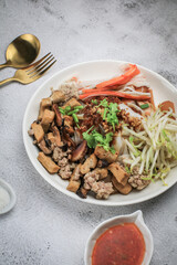 Chinese Steamed Rice Noodles with pork ,sausage,imitation Crab Stick,boil bean sprouts,mushroom and tofu in sweet soy sauce.Chili powder,pickled chili and sugar on table - asian food style