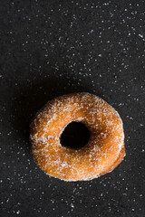 Una sola dona azucarada con azúcar esparcida