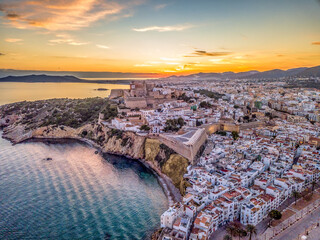 Aerial view of stunning sunset over Ibiza (Evissa) during a winter evening with view of the medieval fortress and the old town - obrazy, fototapety, plakaty