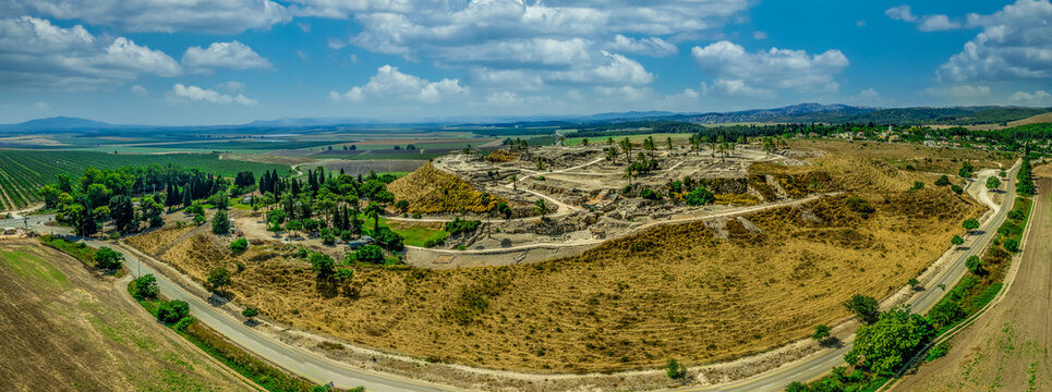 Aerial panorama of the ruins of the ancient city of Tel Megiddo, archaeological park, site of the biblical Armageddon in Israel with cloudy sky