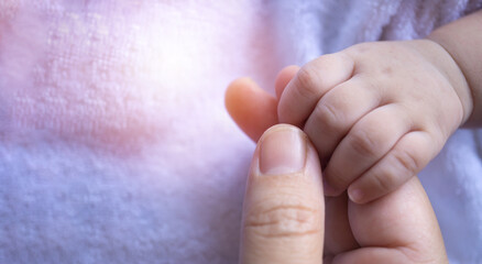 Close up mother hand holding baby hand. Selective focus..