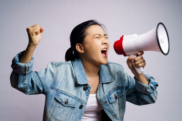 Asian woman shouting with megaphone isolated over white background.