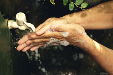 Man washing his hands with soap and running water