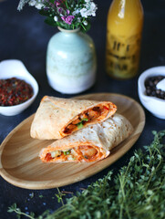 pita sandwich with chicken and vegetables on dark background