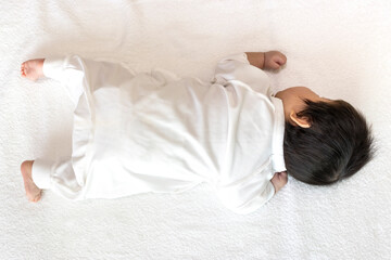 うつ伏せになっている生後2ヶ月の赤ちゃんの全身