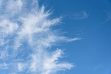 Fresh air, bright blue sky with wispy white clouds, as a nature background
