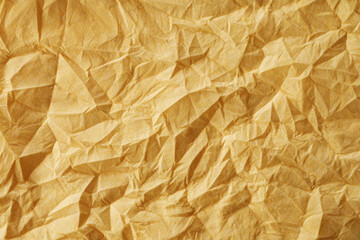 Obraz premium The texture of a crumpled yellow-gold disposable textile napkin.