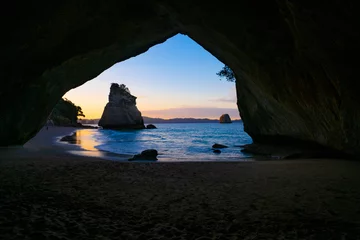 Fotobehang Te Hoho Rock standing in sun framed by the natural arch of Cathedral Cove on Coromandel Peninsula New Zealand. © Brian Scantlebury