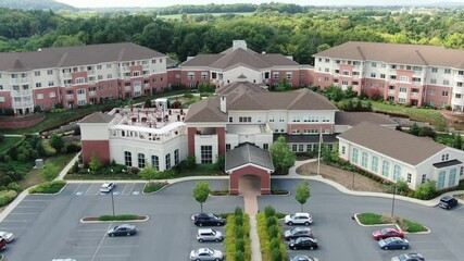 Descending aerial on retirement home community, assisted living, senior citizen home, large CCRC complex for continuing care, United States of America, USA Baby Boomer generation, healthcare facility