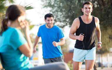Portrait of adult man who is jogging with friend in the park near ocean.