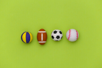 Mini balls of different sports on green background. Minimalism Sport concept. Top view. Flat lay.