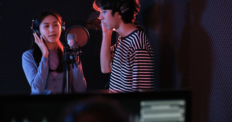 Young asian attractive musicians happy singing together recording new song