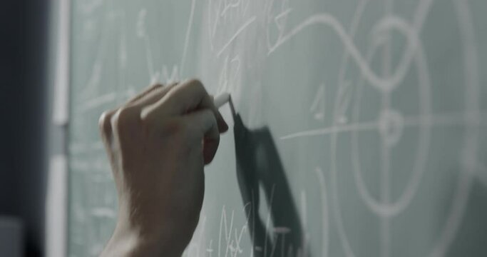 Creative mathematician writing formulas on the chalkboard