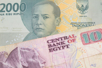 A macro image of a grey two thousand Indonesian rupiah bank note paired up with a pink and purple ten pound bank note from Egypt.  Shot close up in macro.