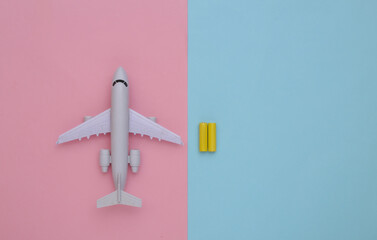 Toy air plane and batteries on a blue-pink pastel background. Top view