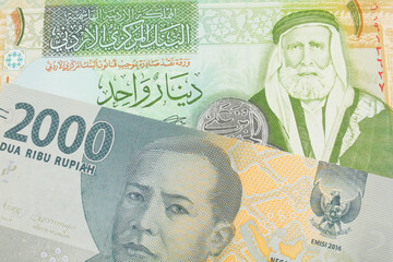 A macro image of a grey two thousand Indonesian rupiah bank note paired up with a green and yellow one dinar note from Jordan. Shot close up in macro.