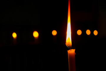single candle lit in a dark room