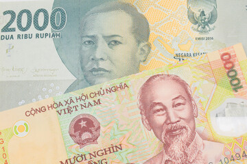 A macro image of a grey two thousand Indonesian rupiah bank note paired up with a yellow one thousand dong bill from Vietnam.  Shot close up in macro.