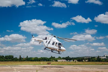 Fototapeten Ein weißer Helikopter hebt von der Landebahn ab © Oleksii Halutva