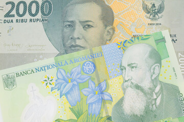 A macro image of a grey two thousand Indonesian rupiah bank note paired up with a green, plastic one leu bank note from Romania. Shot close up in macro.