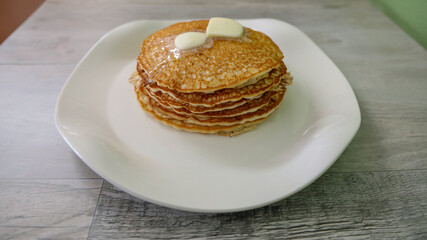 A stack of delicious pancakes with butter on top.