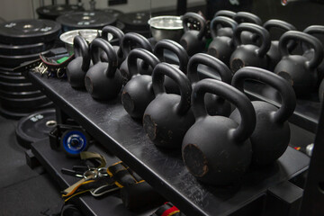 Naklejka na ściany i meble Bodybuilding, free weight equipment. A rack with kettlebells and fitness accessories in a modern gym. Functional training