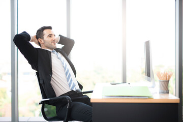 businessman sitting with feet on table in office.